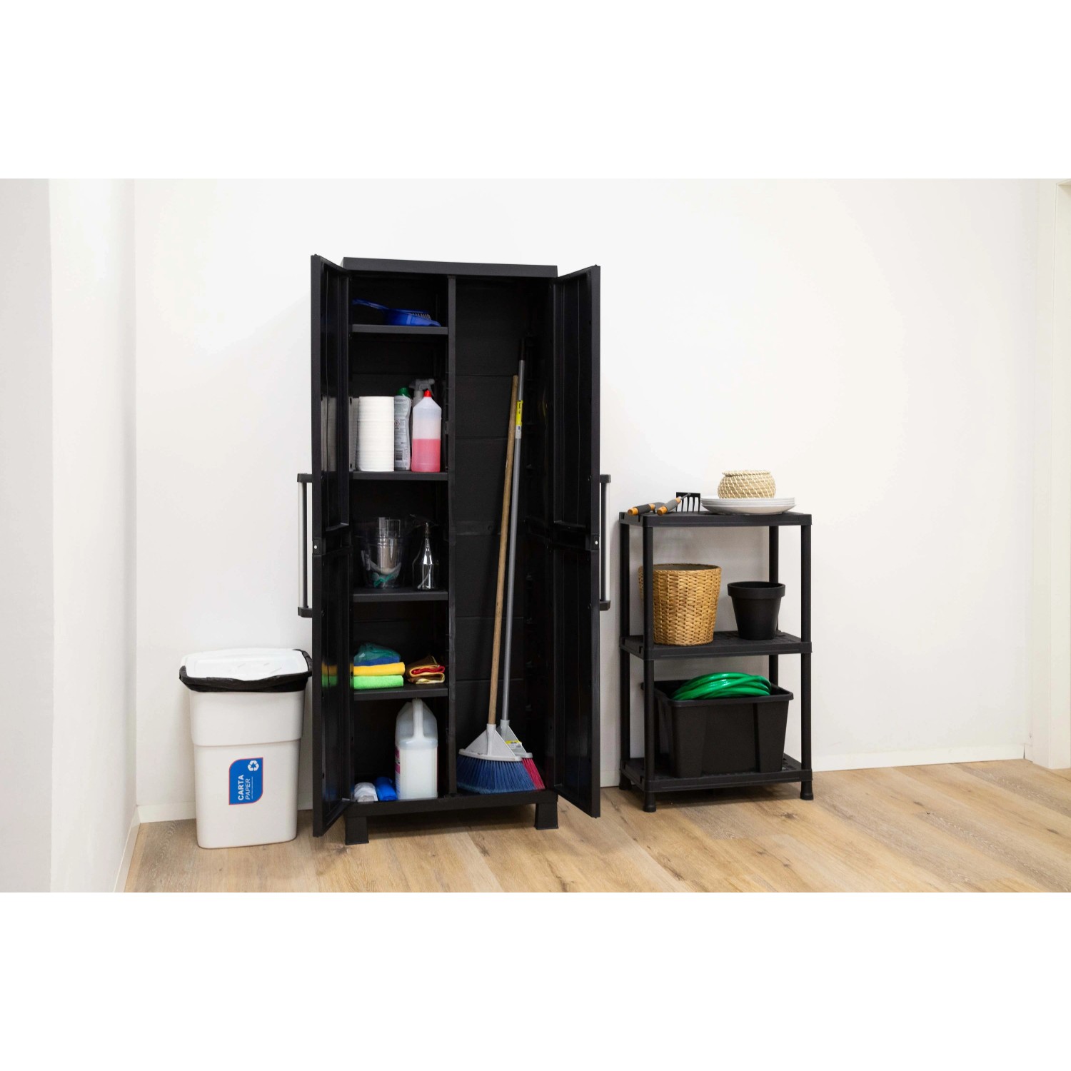 Armadio da giardino in plastica nera con ripiani e prodotti per la pulizia.