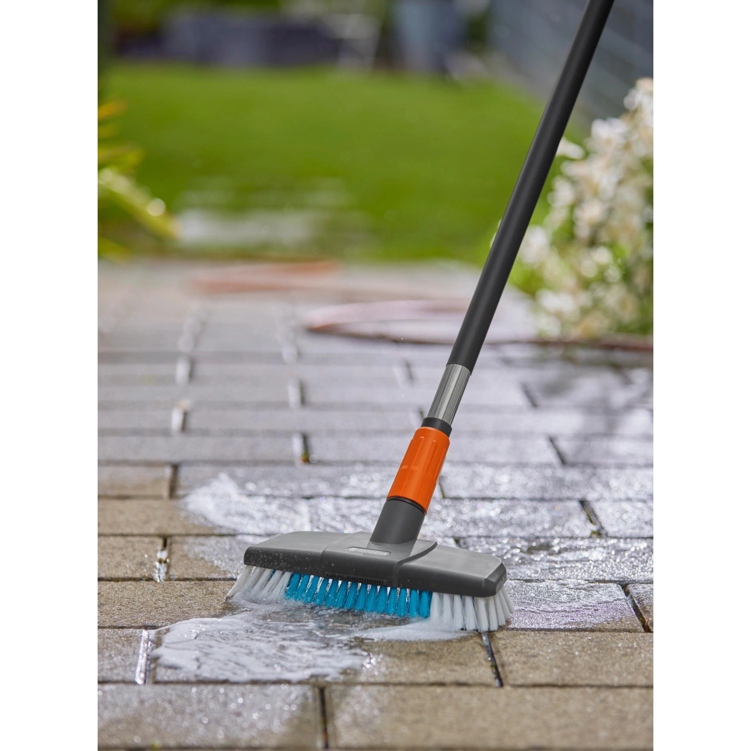 Gardena Cleansystem Spazzola Hard in azione: pulizia pavimentazione con acqua e spazzola.
