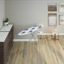 Asse da stiro con rivestimento bianco e blu nella stanza.