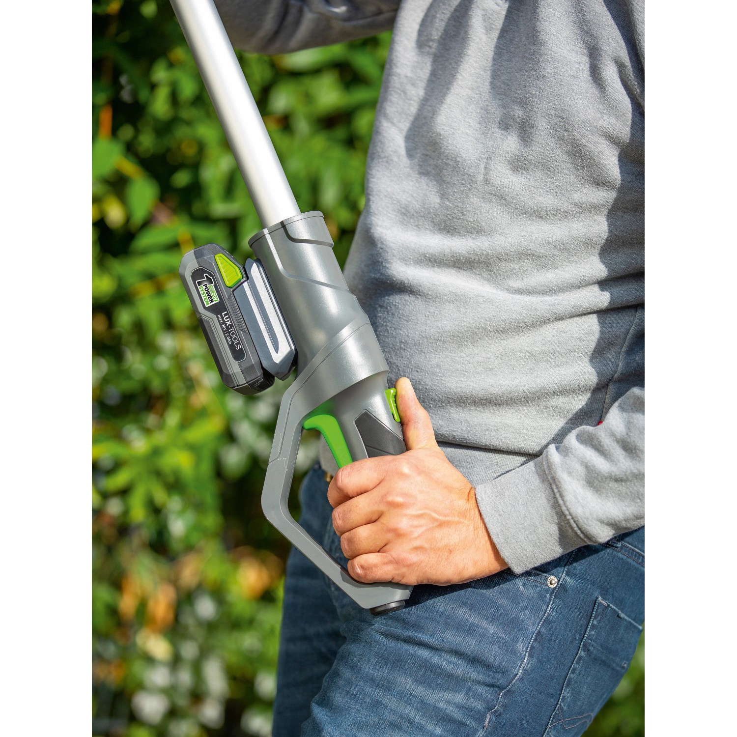 Tagliasiepi telescopica a batteria LUX A-HS-20/51T con batteria in uso, per una comoda potatura.