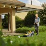 Donna usa tosaerba a batteria Stiga Collector 136e in giardino. Include batteria e caricabatterie.