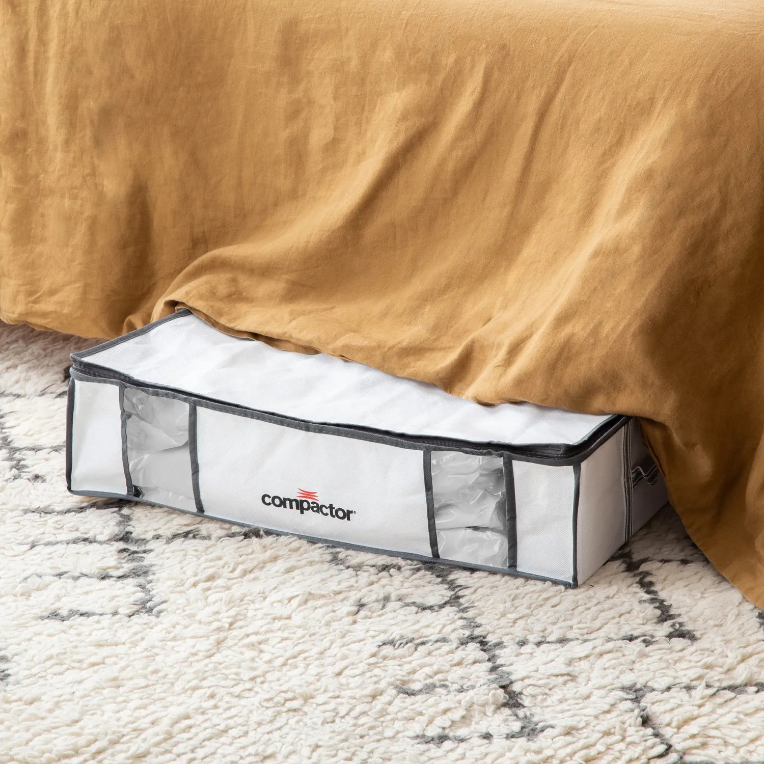 Contenitore bianco t.b.t. sotto un letto su un tappeto.