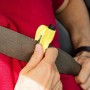 Moschettone t.b.t. giallo fissato alla cintura di sicurezza dell'auto.