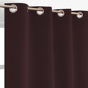 Tenda in tessuto rosso scuro con occhielli.