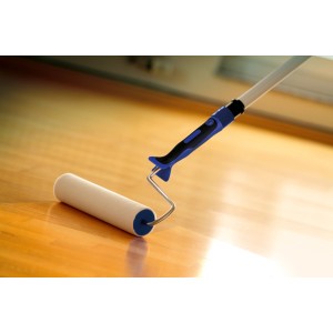 Rullo in feltro LUX 15 cm con impugnatura morbida che applica vernice su pavimento in legno.
