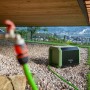 Pompa a pressione t.b.t. in giardino con rubinetto e tubo. Irrigazione facile.