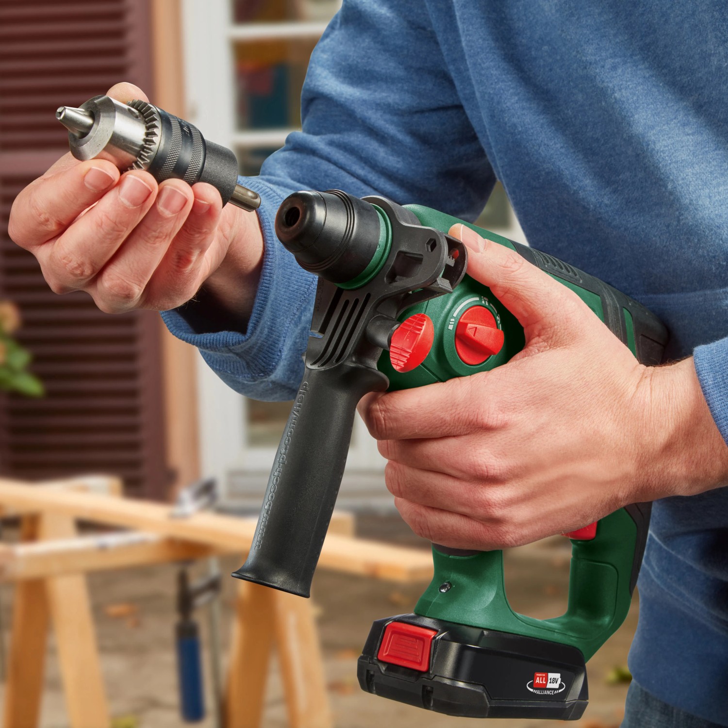 Trapano a percussione a batteria Bosch UniversalHammer 18V con mandrino in mano, trapano a percussione a batteria verde/nero.