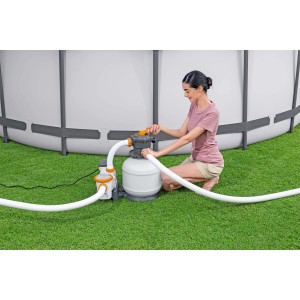 Sistema di filtraggio a sabbia per piscina in uso: donna aziona il filtro.