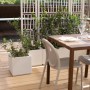 Fioriere da esterno t.b.t. quadrate bianche con piante e grigliato su una terrazza.