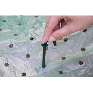 Supporto per reti e teli (10 pz.) in uso: gancio verde scuro fissa il telo nell'aiuola.