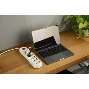 Multipresa t.b.t. bianca con laptop su tavolo di legno.