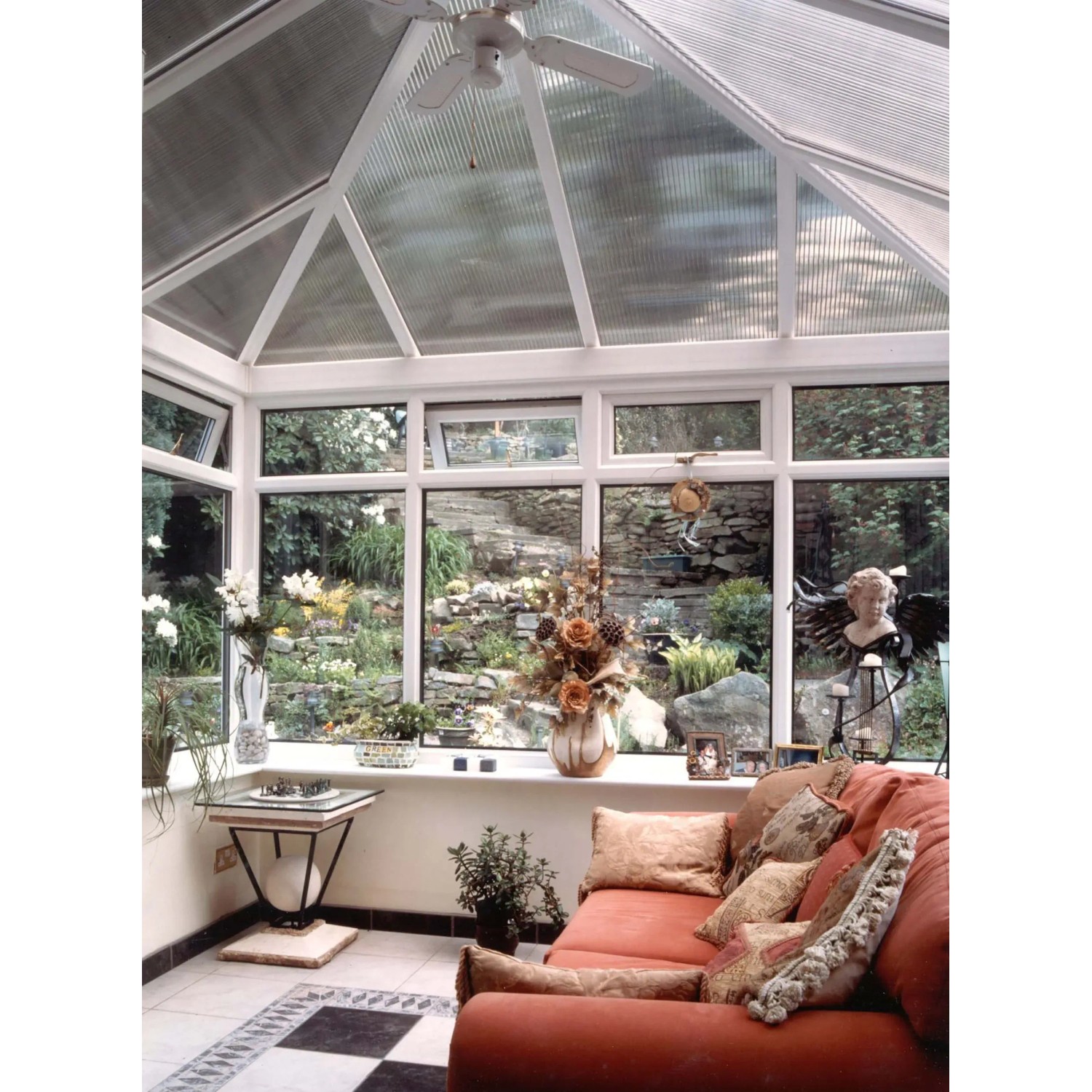 Veranda con pannelli in plastica t.b.t. trasparenti e vista sul giardino.