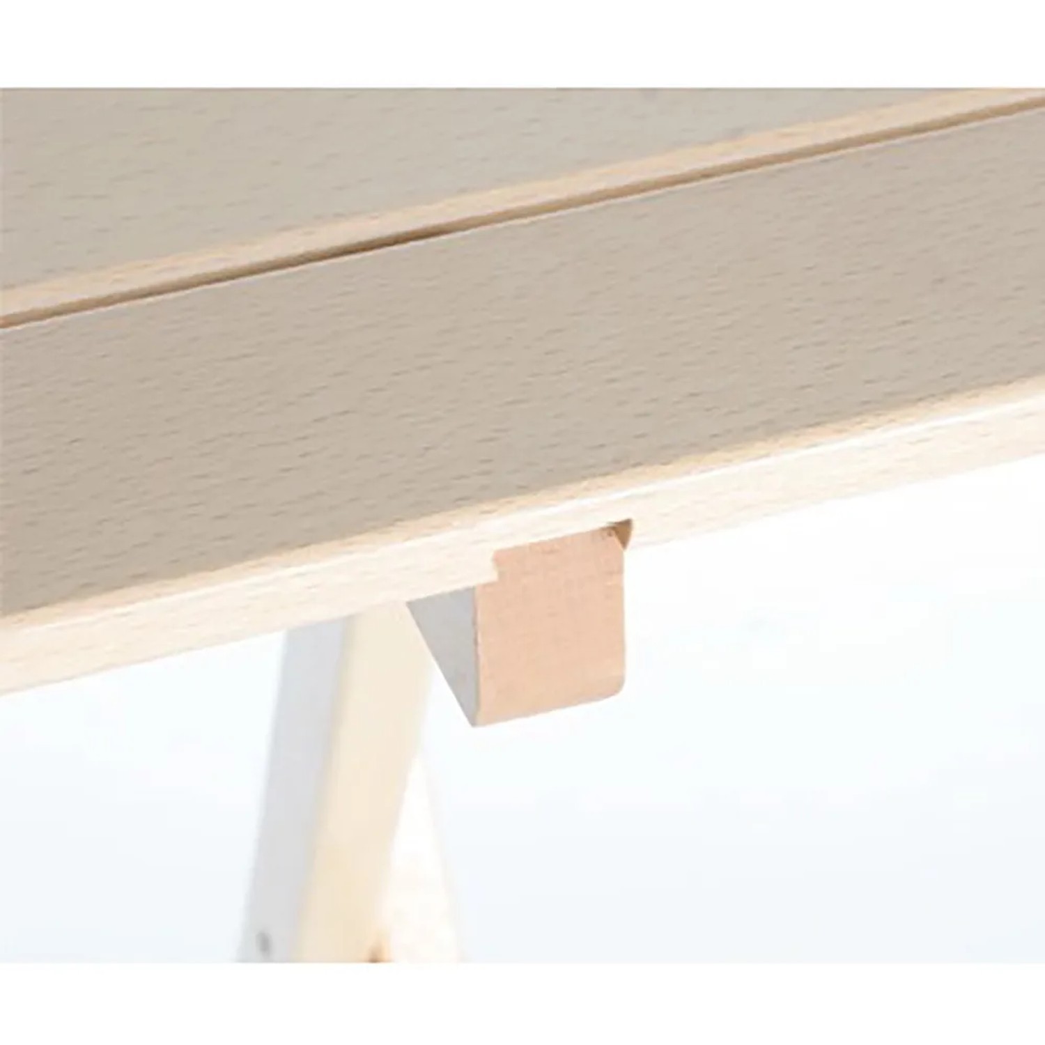 Dettaglio di un tavolo da giardino: Piano in legno chiaro e attacco gamba.