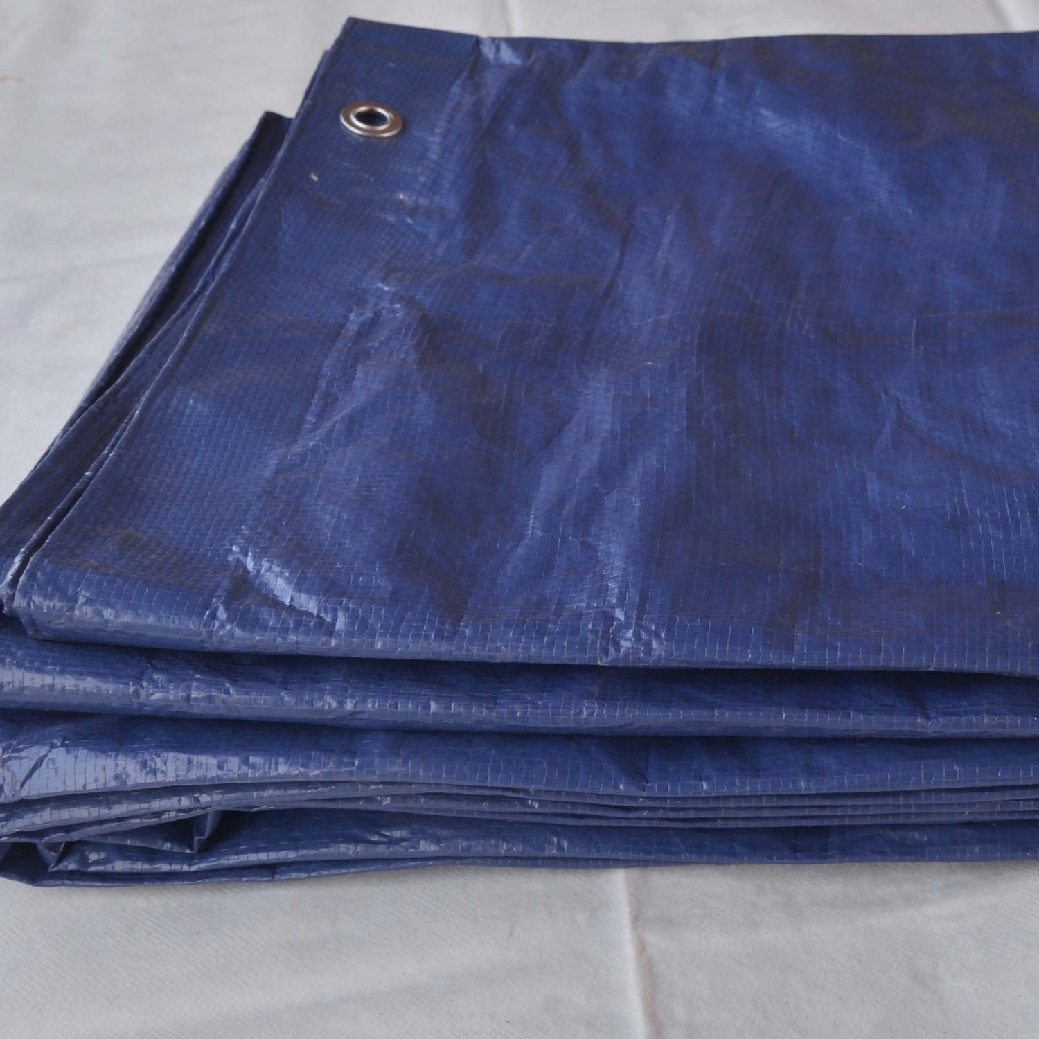 Telone di copertura blu con occhielli, impilato.