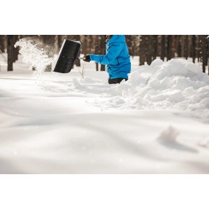 Persona che spalare la neve con lo spalaneve telescopico Fiskars X-series.