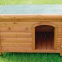 Cuccia per cani in legno con tetto verde su prato. Costruzione robusta per esterni.