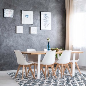 Tappeto moderno con motivo blu e bianco sotto un tavolo da pranzo.