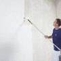 Uomo che applica Knauf SuperFinish con rullo sulla parete.