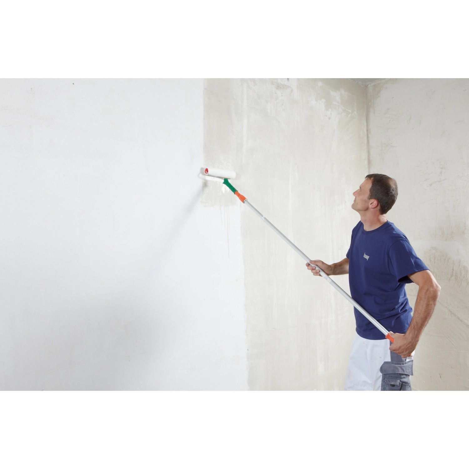 Uomo che applica Knauf SuperFinish con rullo sulla parete.