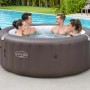 Vasca idromassaggio gonfiabile Lay-Z-Spa marrone con quattro persone in giardino.