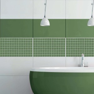 Piastrelle a mosaico verdi come decorazione murale in bagno con vasca verde.
