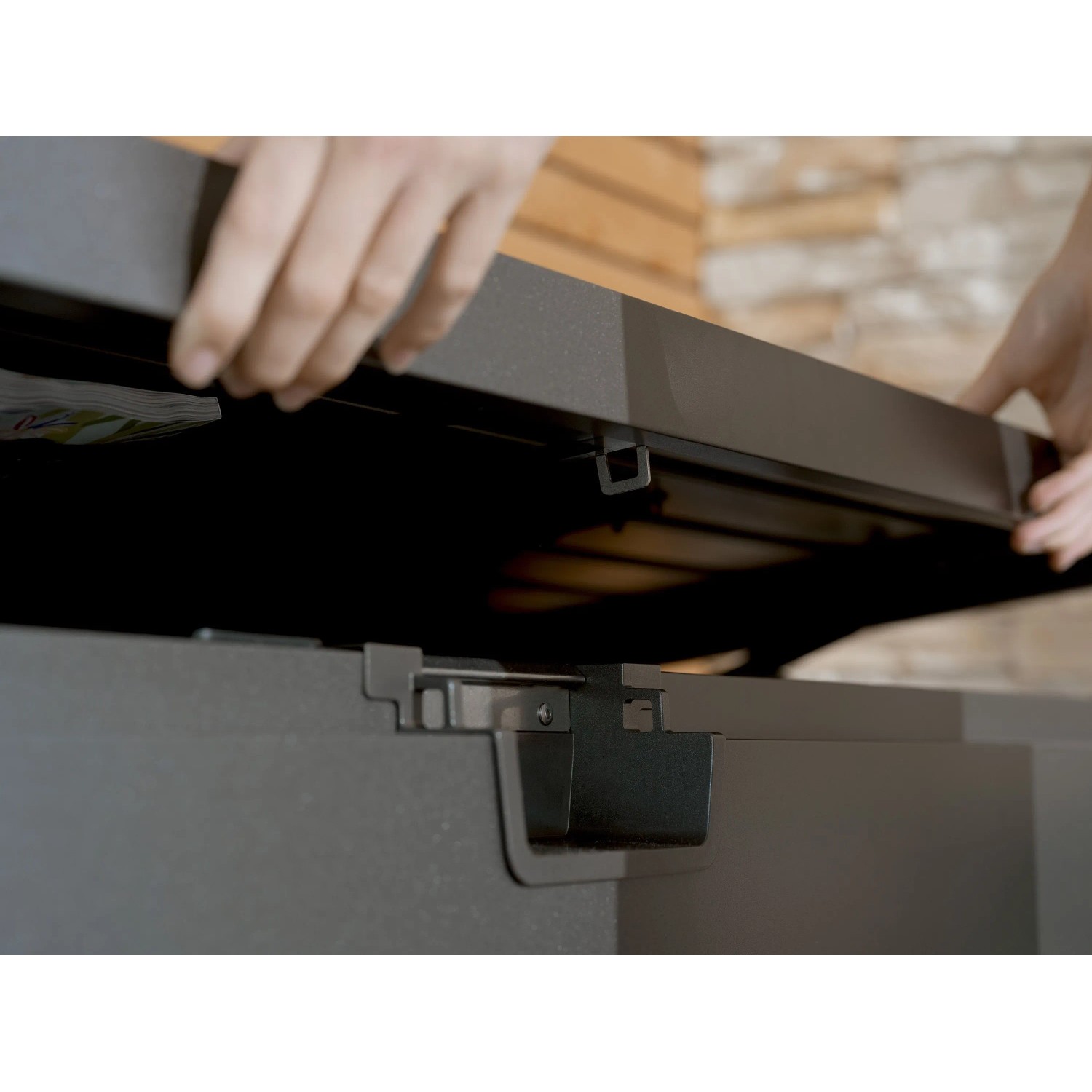 Mani aprono coperchio grigio scuro metallizzato della Biohort StyleBox 170 con molla a gas.