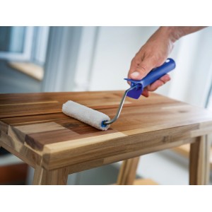 Rullo per impregnante LUX 12cm in azione: rullo in microfibra bianca con manico blu che applica l'impregnante sul legno.