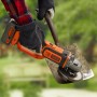 Smerigliatrice angolare a batteria Black+Decker 18V in uso, smerigliatura di una pala in giardino.