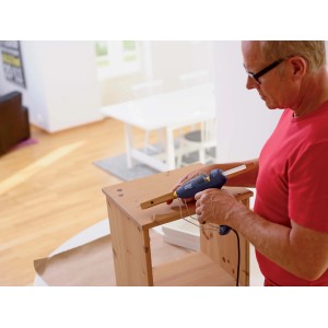 Utilizzo di una pistola per colla blu per incollare listelli di legno su un mobile in legno.