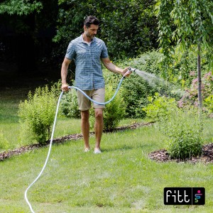 Uomo che irriga il giardino con tubo per irrigazione t.b.t.