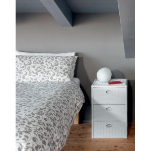 Cassettiera bianca t.b.t. con tre cassetti accanto a un letto in una camera da letto.