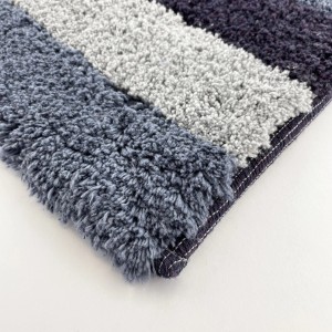 Tappeto da bagno a righe nei toni del grigio e del blu, dettaglio.