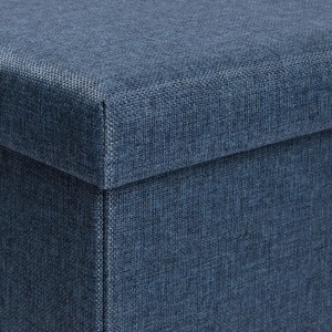 Dettaglio di un pouf blu con rivestimento in tessuto.