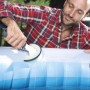 Uomo pulisce la piscina con una spazzola. Accessori per la cura e la pulizia della piscina.