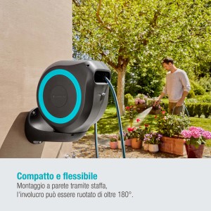 Avvolgitubo a parete con tubo in giardino che annaffia i fiori.