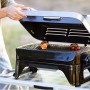Campingaz Barbecue a gas Attitude 2go CV con cibo sulla griglia, barbecue da tavolo per campeggio e balcone.