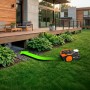 Robot rasaerba Worx M800 Vision senza cavo in giardino con freccia verde verso la stazione di ricarica.