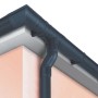 Grondaia e pluviale in plastica grigio scuro su un tetto di casa.