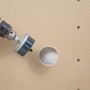Set di seghe a tazza LUX (9 pezzi) in uso: foratura di un foro in una tavola di legno chiara.
