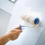 LUX Rullo a dispersione ruvido 18 cm in uso: rullo che dipinge una parete bianca.