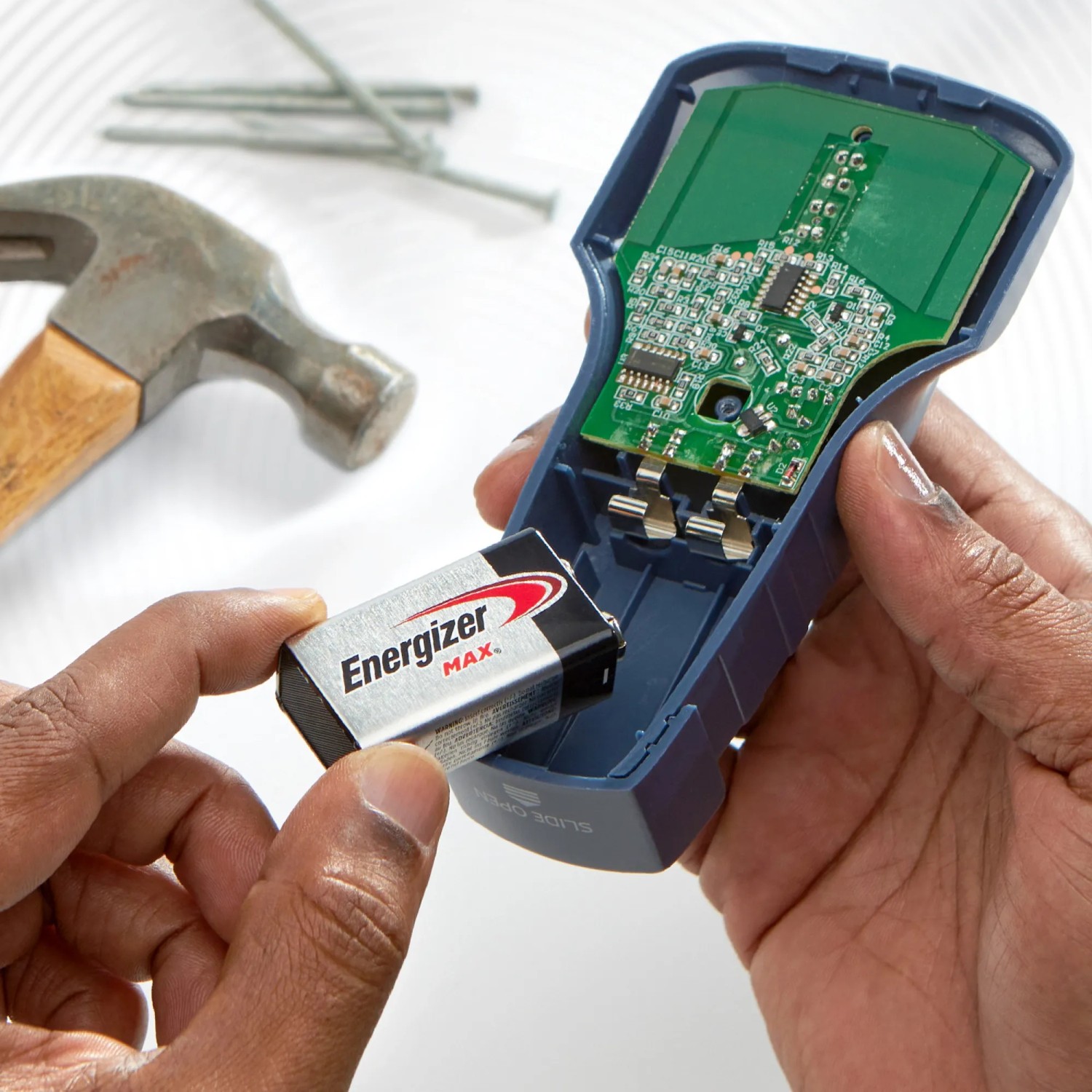 Batteria Energizer 9V inserita in un dispositivo elettronico. Attrezzi sullo sfondo.