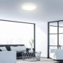 Plafoniera LED Brilo Slim 22W rotonda bianca illuminata, montata su un soffitto del soggiorno.