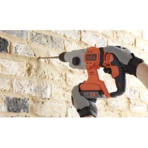 Martello perforatore a batteria Black+Decker BCD900B 18V durante la foratura di un muro di mattoni.