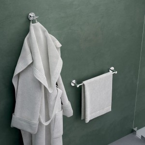 Accessori bagno: Porta asciugamani e accappatoio su parete verde.