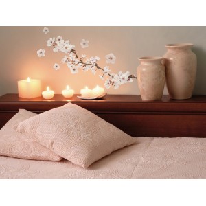 Decorazione murale con motivo di fiori di ciliegio t.b.t. sopra comò con candele e vasi.
