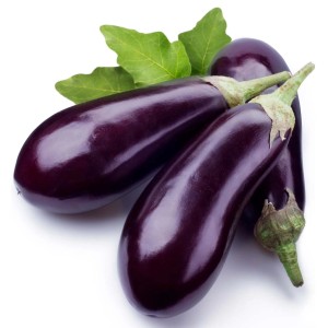 Tre melanzane (Ortaggi da frutto) viola lucide con foglie verdi.