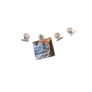 Piccole clip magnetiche argentate, una tiene una foto. Categoria: Bacheche.