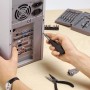 Set di meccanica di precisione in uso: cacciavite su computer, pinze e punte nel set.