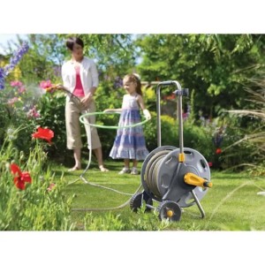 Avvolgitubo grigio con dettagli gialli in uso in giardino.