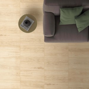 Piastrelle per pavimenti chiare effetto legno, posate in un soggiorno con divano e tavolino.